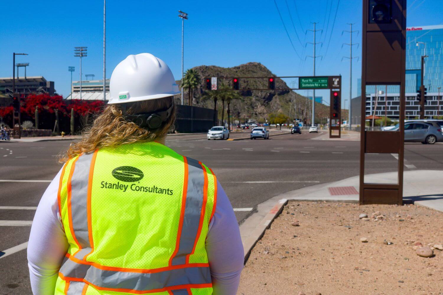 Woman standing near intersection, wearing Stanley Consultants vest