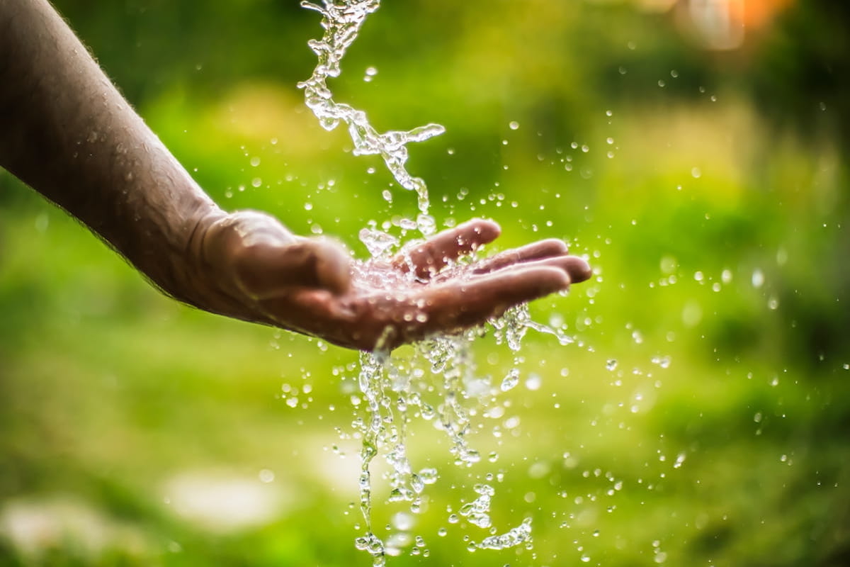 Fresh water pouring over outstretched hand