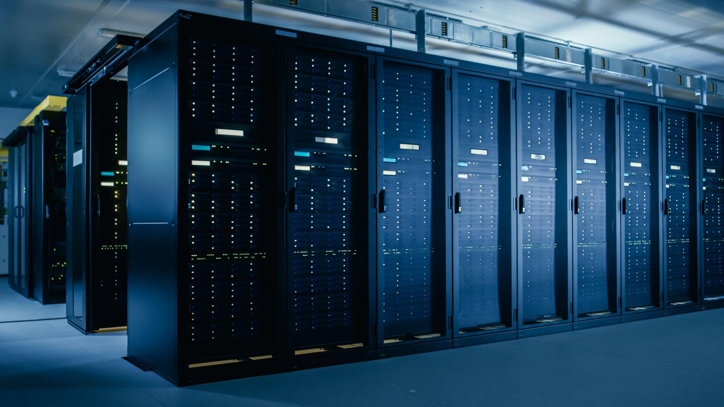 Rows of high-performance server racks in a modern data center, illuminated with blue lighting.