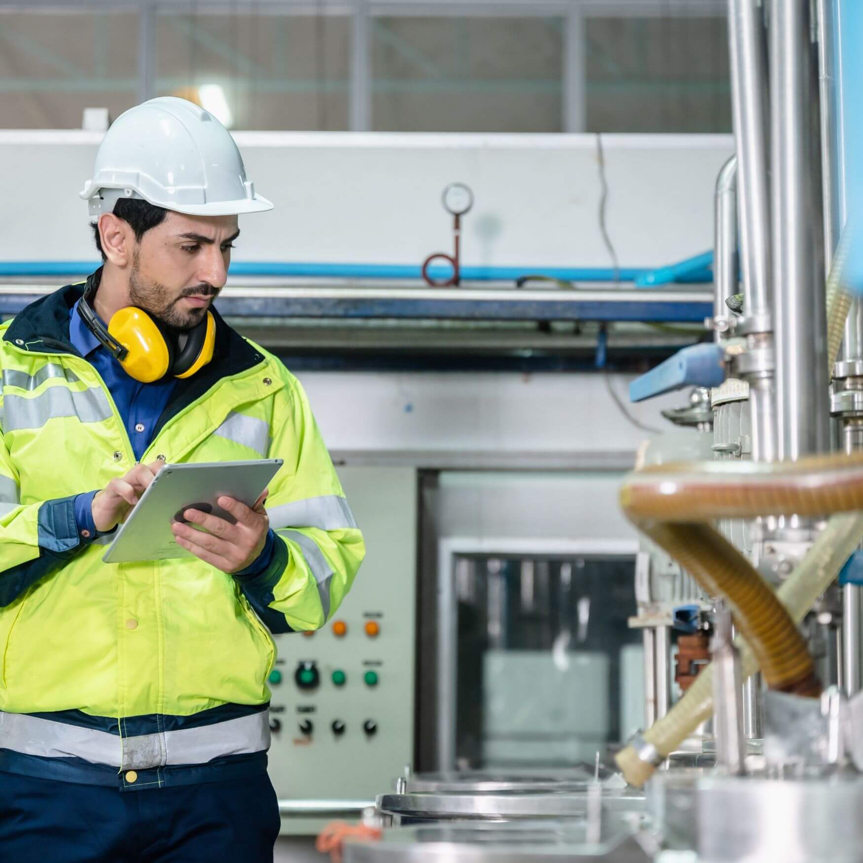 Water treatment technician using a tablet to monitor industrial water processing equipment